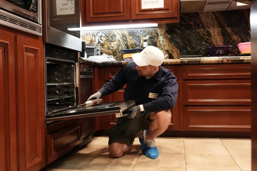 Senior tech servicing a Wolf oven on-site